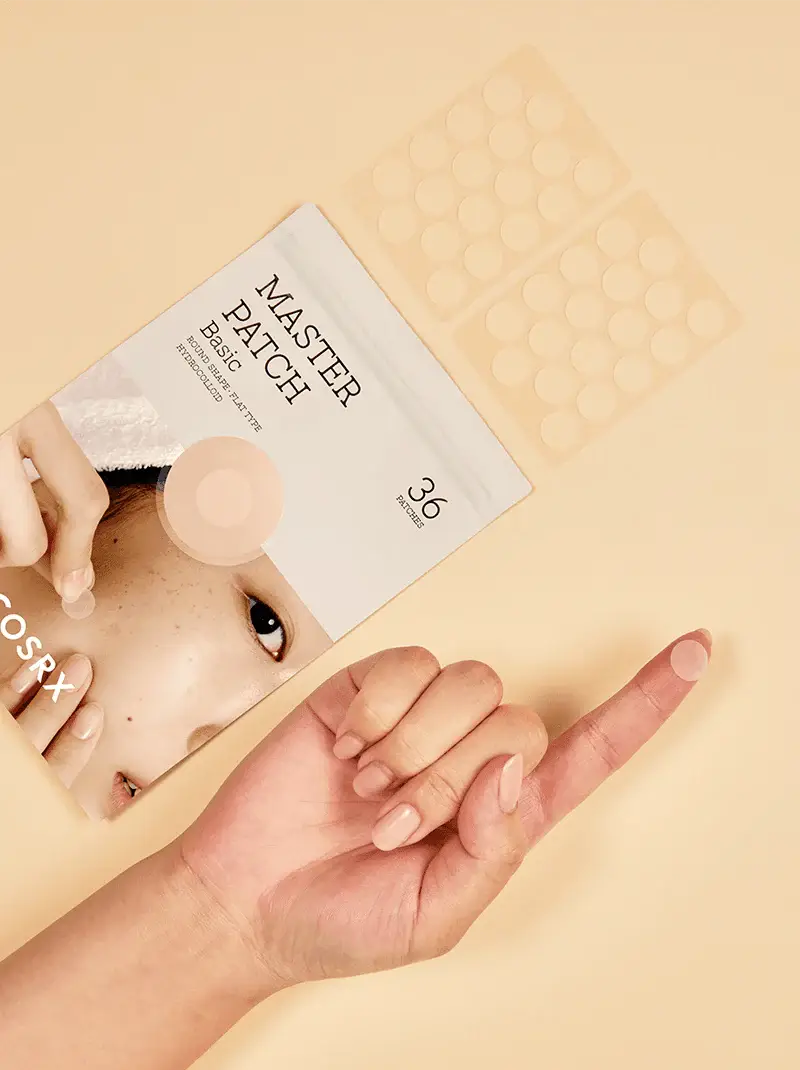 Person applying a patch to their face with a 'Master Patch' packaging on a beige background