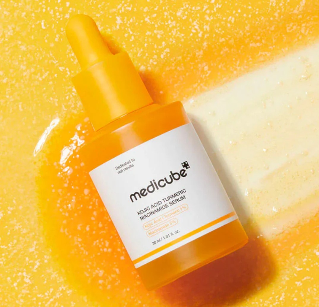 Mdicube Kojic Acid Serum Bottle on Serum texture backround
