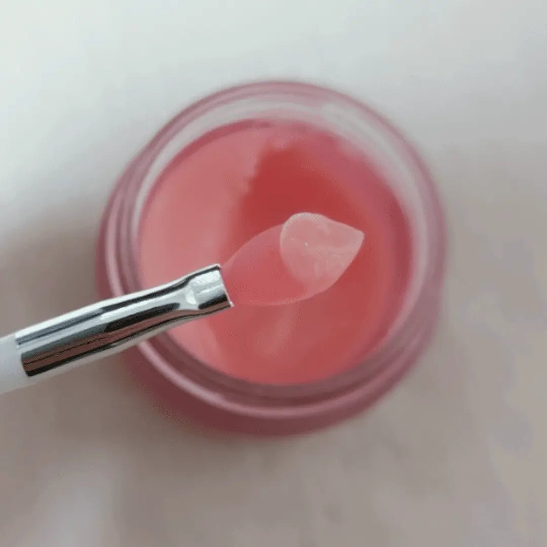 Pink lip balm with a applicator on a light pink background
