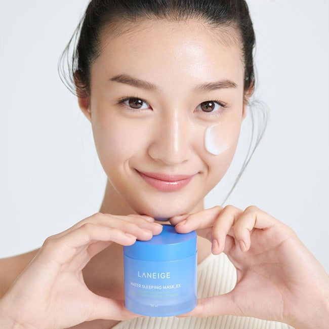 Woman applying cream to her face with a Laneige product in the foreground