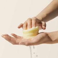 Hand holding stack of vita c pads with water dripping