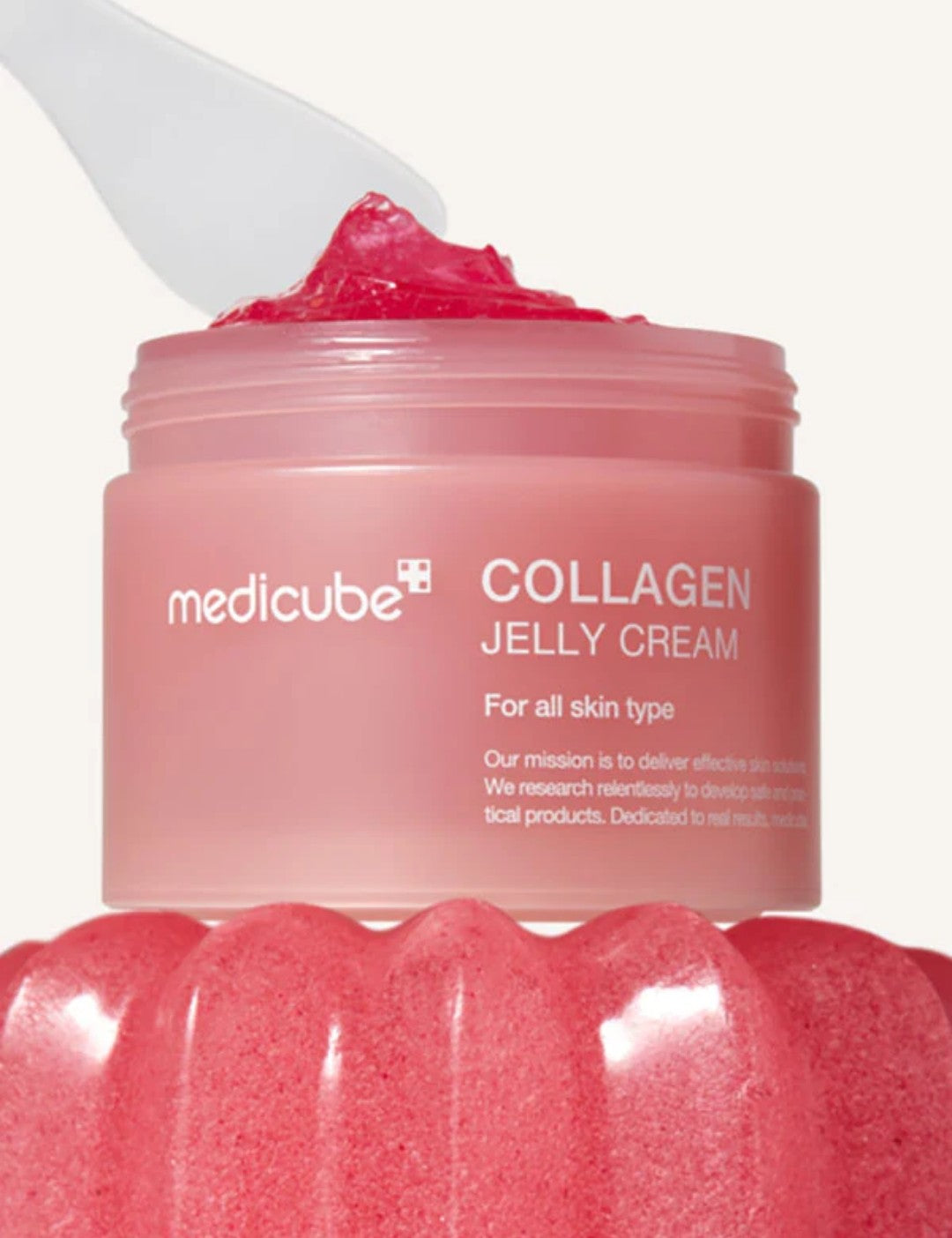 Pink jar of Medicube Collagen Jelly Cream with a spoonful of cream on top.